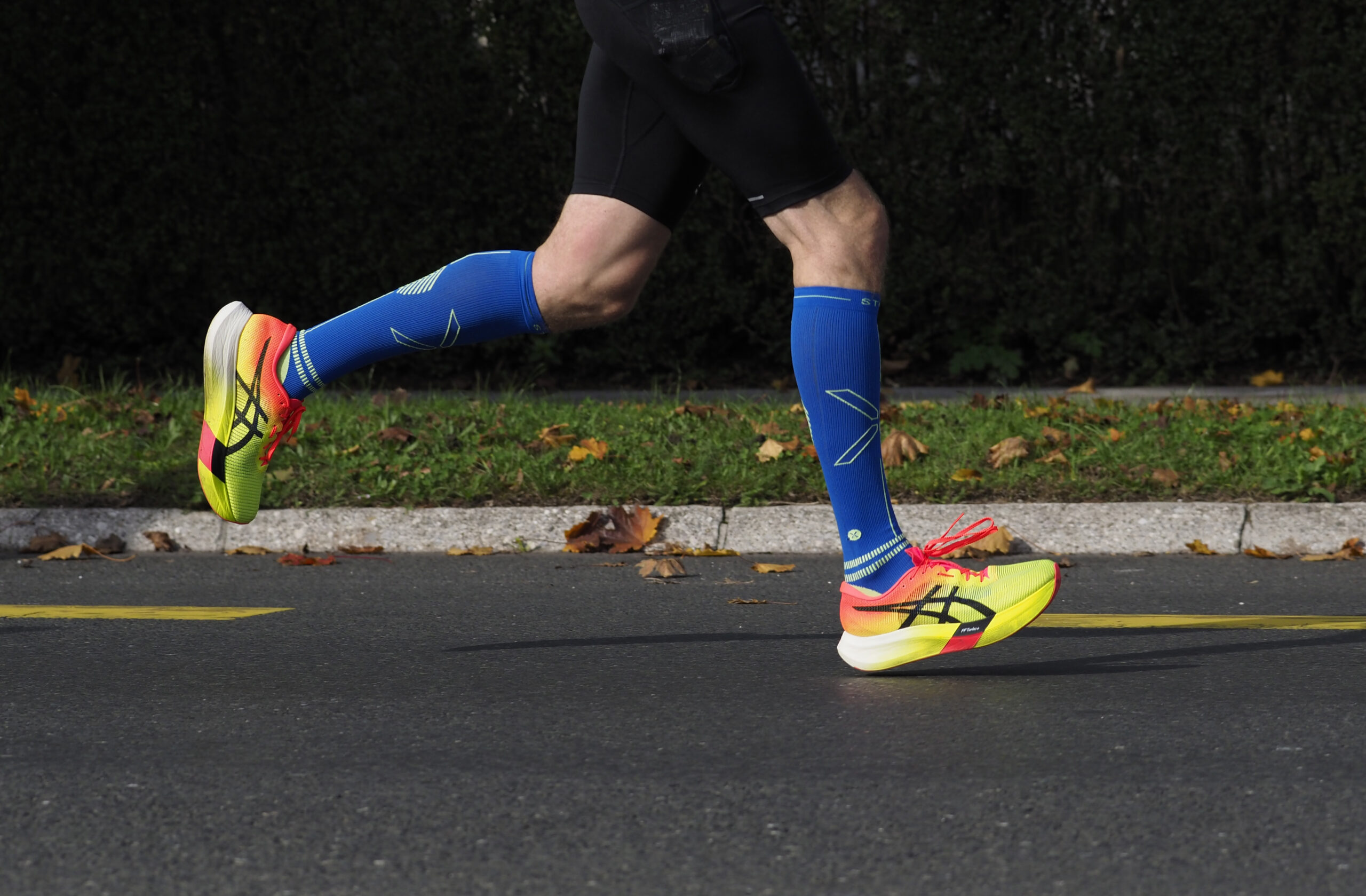 A marathon runner's legs and feet mid-stride on a road