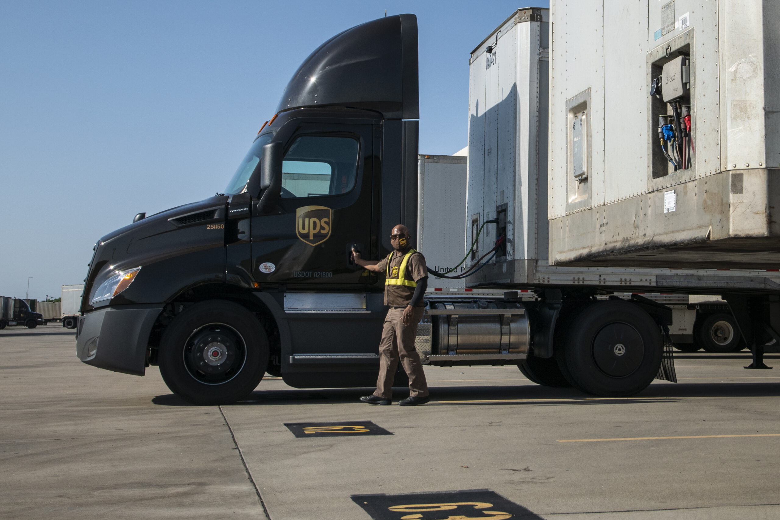A truck driver standing beside his semi-trailer truck