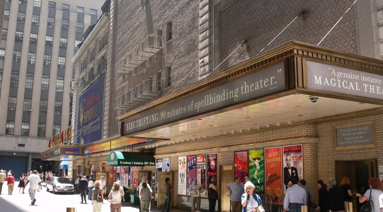 Crowds walk past the Shubert and Booth Theatres in the Broadway theater district of New York City